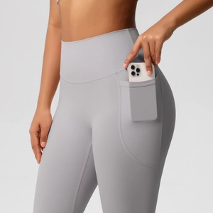 Detail shot of high-waisted gray yoga pants featuring a functional side phone pocket