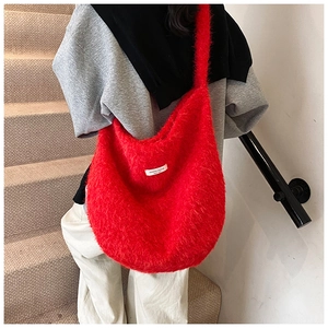 Red faux fur hobo bag shown on model's shoulder for a cozy winter outfit style