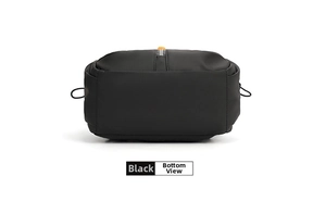 Detailed bottom view of black functional chest bag showing durable nylon and orange zipper