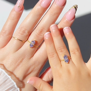Detail of adjustable gold chain ring with two purple heart-shaped cubic zirconia stones