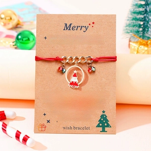 Handmade Christmas tree charm bracelet with red braided cord on holiday wish card