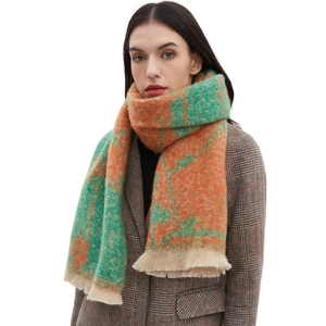 Women's orange and green floral jacquard knit scarf with beige tassels on studio model