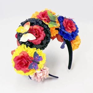 Detail of vibrant Day of the Dead headband with colorful artificial flowers and butterflies