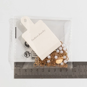 Detail view of multi-layer gold pearl necklace with scale ruler for size measurement