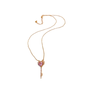 Rose gold key necklace with pink heart gemstone and zircon accents on white background