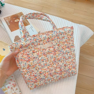 Detail of quilted floral handbag with simple wish label and soft padded cotton texture