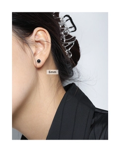 Detail view of 6mm round black onyx stud earrings on model in S925 sterling silver