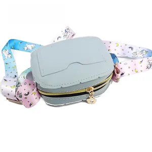 Detail of light blue unicorn cross body bag with colorful rainbow strap and floral zipper charm