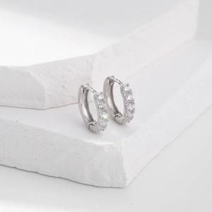 Macro shot of silver hoop earrings with micro-pave white zircons on stone display