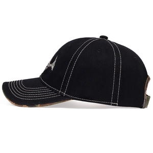 Detail of baseball cap with camouflage under-brim, white stitching and embroidery