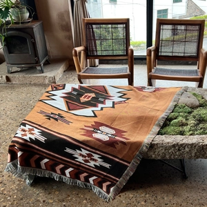 Detail of bohemian woven blanket with Aztec geometric patterns and tassel fringe finish