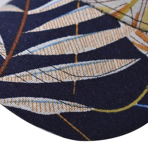 Macro shot of tropical leaf print detail on a navy cotton baseball cap fabric