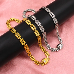 Detail view of gold and silver H-link chain necklaces with cubic zirconia on black stand