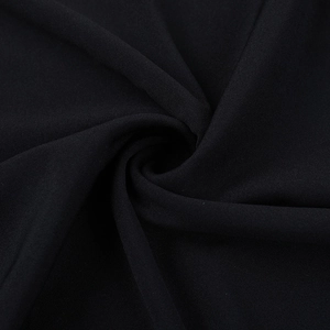 Vista dettagliata del tessuto a maglia nera con un elegante motivo a pieghe a spirale