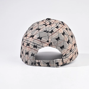 Macro detail of khaki plaid baseball cap featuring black butterfly print and metal buckle