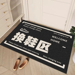 Black PVC loop entryway mat with Shoe Changing Area text on wooden floor background