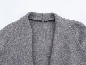 Close-up of gray knit cardigan neckline and shoulder with ribbed texture detail