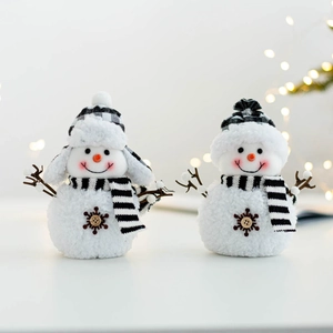 Detailed close-up of plush Christmas snowmen featuring knit scarves and wooden buttons