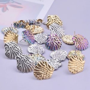 Detailed view of 304 stainless steel shell-shaped stud earrings in gold, silver, and aurora