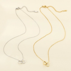 Close-up of interlocking double heart pendants in gold and silver stainless steel