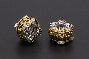 Macro view of retro skull and cross patterns on gold-silver tone metal spacer beads