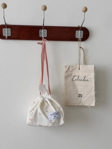 Detail of drawstring tissue bag with pink bow pattern and high-quality cotton linen texture