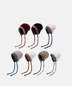 Détails de bonnets en maille épaisse avec cache-oreilles et bordure contrastée d'hiver
