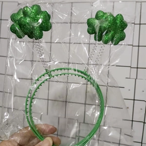 Green glitter shamrock headband with spring attachments for St. Patrick's Day celebration