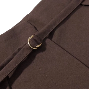 Gros plan détaillé du tissu marron foncé avec boucle métallique dorée et bretelle fine