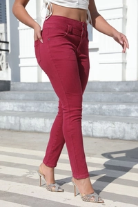 Outdoor street shot of burgundy high-waisted slim-fit jeans highlighting the sleek silhouette