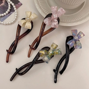 Detail of elegant resin bow hair clips with marble texture and small rhinestone accents