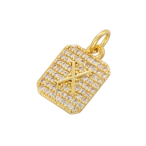 Macro detail of gold-plated square pendant with pavé cubic zirconia and letter X design
