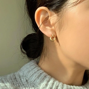 Close-up of a gold hollow circle stud earring on a model with minimalist modern style