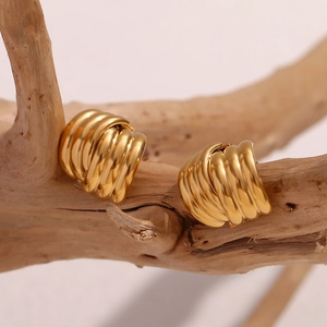 Three-layer striped 18K gold plated stainless steel cross earrings on a wooden stand