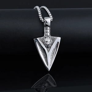 Macro shot of silver punk wolf head arrowhead pendant with polished steel box chain