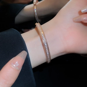 Detailed view of luxury rose gold pave zircon bracelet with beaded edges on a wrist