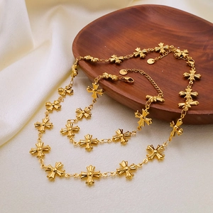 Detail of gold cross necklace and bracelet set on dark wood tray and silk background