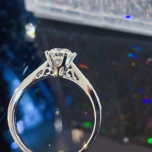 Classic six-prong 18K white gold engagement ring with round diamond and side heart detail