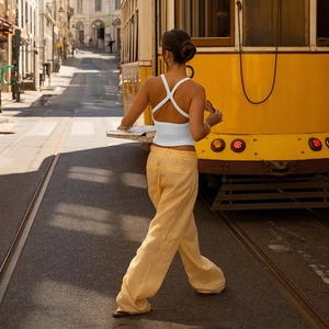 Estilo callejero con top halter blanco y pantalones anchos de lino amarillo de moda