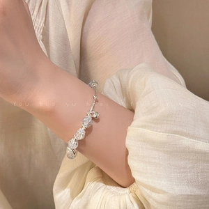 Detail of beaded bracelet featuring ice-cracked round beads and silver butterfly charms