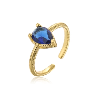 Detail of gold-plated ring with pear-shaped blue gemstone and twisted rope texture