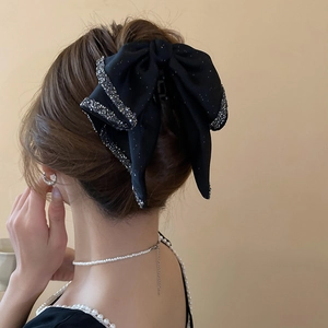 Detailed back view of a large black bow hair claw with sparkling rhinestone lace edges