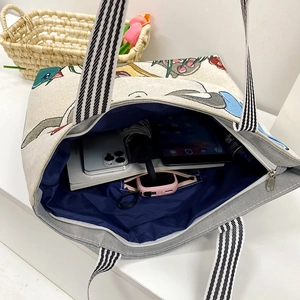 Spacious canvas tote bag with cartoon animal print and striped handles for daily use