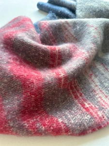 Détail macro de la texture léopard pelucheuse sur une écharpe rose et grise style cachemire