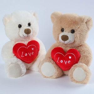 Plush teddy bears in white and light brown holding red Love heart cushions