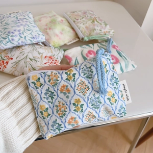 Detailed macro shot of floral cotton storage pouches with simple wish woven labels