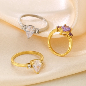 Detailed shot of pear-cut cubic zirconia rings on elegant beige silk fabric