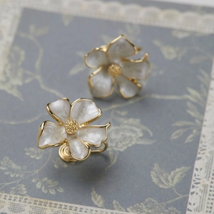Eleganti orecchini a clip a forma di gelsomino con bordo dorato e petali bianchi perlati