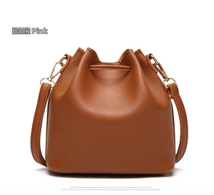 Back view of a caramel brown leather bucket bag with drawstring and golden hardware