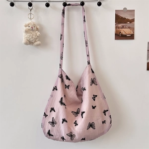 Close-up of lilac cotton shoulder bag featuring black butterfly prints and wrinkled texture